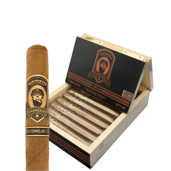A box of Warfighter Tobacco Warfighter 5.56 Garrison Corojo Robusto cigars, featuring a rich Honduran Corojo wrapper, with one cigar in the foreground and several neatly arranged inside the open wooden box.