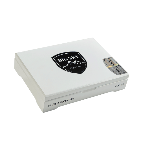 A white rectangular box for the Big Sky Cigars Blackfoot Toro from Big Sky Cigar Co. showcases a striking black "Big Sky" logo on the lid, with "20 Blackfoot 6 x 54" printed along the side. This distinguished cigar, crafted for outdoor enjoyment, features a premium San Andrés wrapper and promises an exceptional smoking experience.