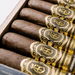 Close-up of a box of cigars with ornate black and gold labels, arranged in neat rows inside a wooden container—these are the renowned Crowned Heads Jericho Hill OBS, expertly crafted using rich Mexican San Andrés wrappers for a bold and memorable smoking experience.