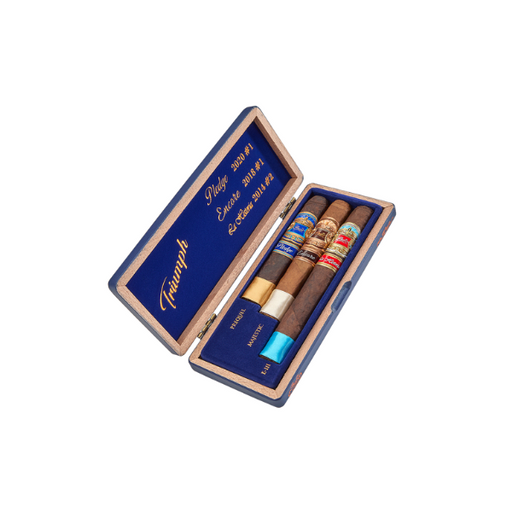 The EP Carrillo Trilogy Sampler by EP Carrillo comes in a wooden box with a blue interior lid labeled "Triumph," holding three award-winning cigars, each with a unique colored band in separate slots.