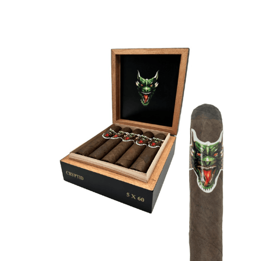 A box of Big Sky Cigar Cryptid Gordo cigars labeled “Cryptid 5 x 60,” with bands showcasing a green, snarling creature’s face. One Cryptid Gordo cigar—featuring a robust Mexican San Andrés wrapper and Nicaraguan core—is displayed upright next to the box.